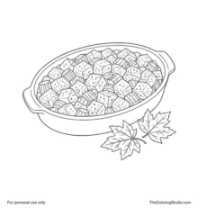 Oval casserole dish filled with golden stuffing beside two large colorful autumn leaves.